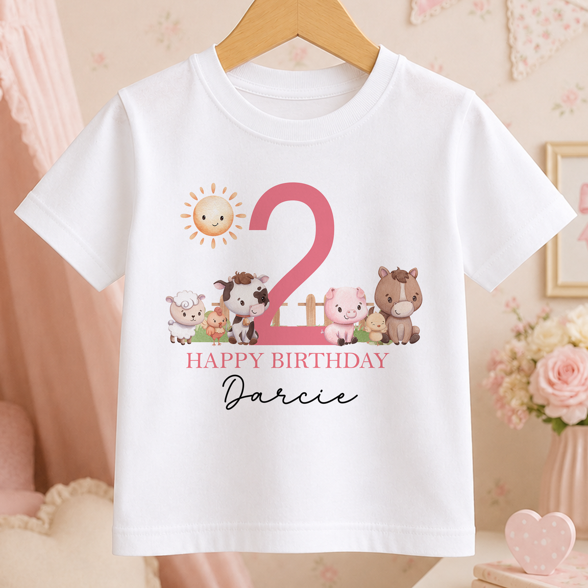 White children's t-shirt on a hanger printed with farm animals, a pink birthday number and the personalised name Darcie.