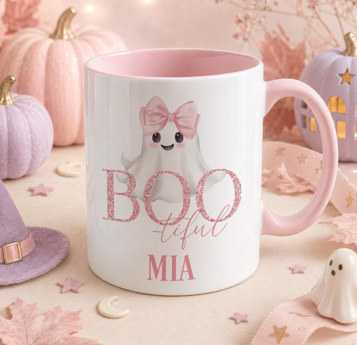 Personalised Halloween mug with a pink handle and inner, featuring a cute ghost wearing a pink bow and glitter-style Boo-tiful text, printed with the name Mia
