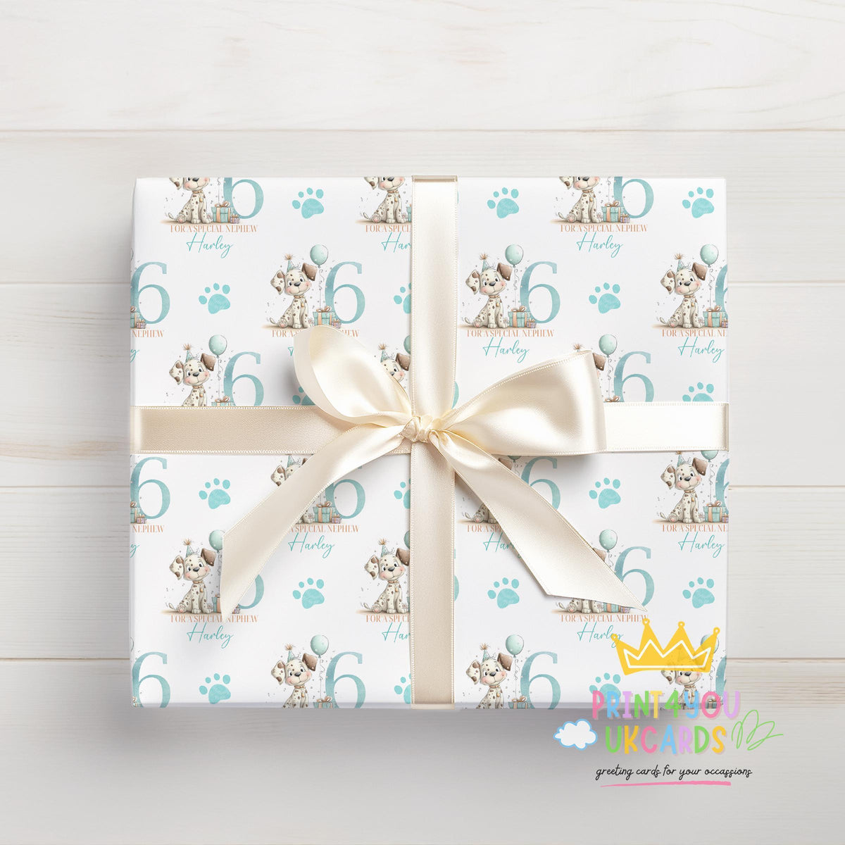 Personalised puppy wrapping paper laid flat, showing the full blue paw print pattern with custom name.