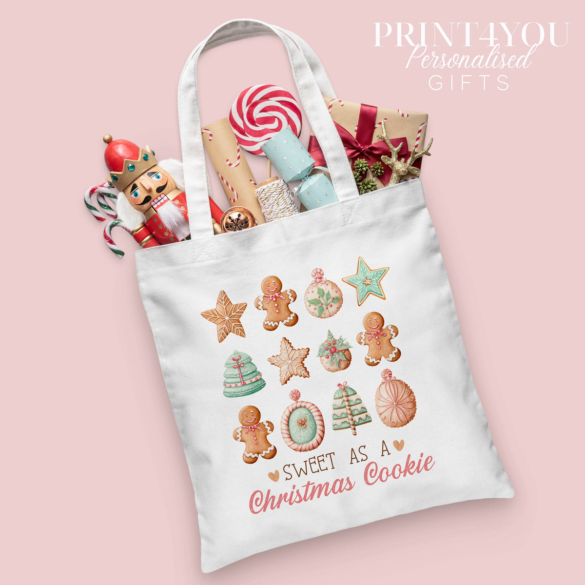 Christmas cotton tote bag printed with a gingerbread and Christmas cookie design and the words 'Sweet as a Christmas Cookie', shown packed with festive nutcracker and gift wrap props