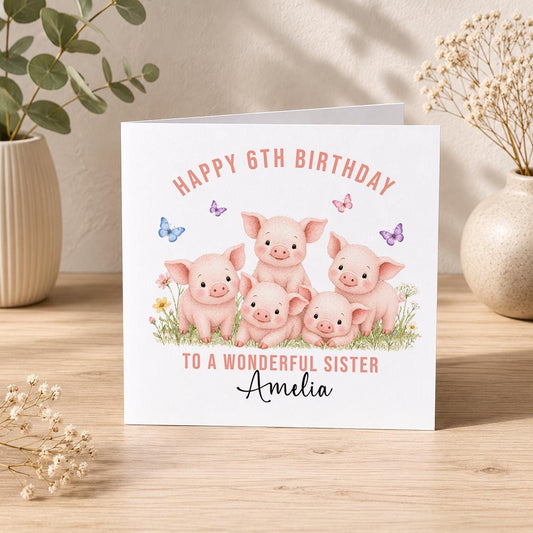 Square birthday card with five pink piglets in a flower field surrounded by butterflies, personalised Happy 6th Birthday to a Wonderful Sister Amelia.