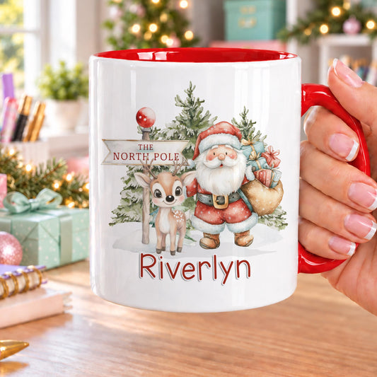 Personalised Christmas mug with red handle and inside, showing Father Christmas and a reindeer by a North Pole signpost in a snowy forest, with a name in red below
