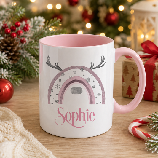 White mug with a pink interior and handle, printed with a reindeer and snowflake Christmas design and the name "Sophie"