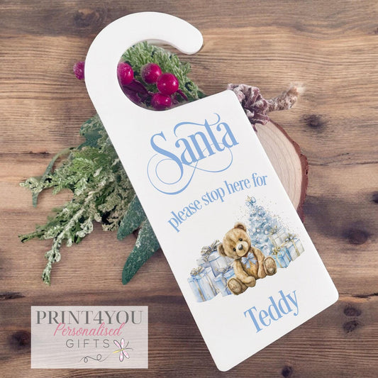 Personalised acrylic Santa Stop Here door hanger with a blue teddy bear ornament, printed with a name