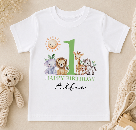 A white t-shirt with a graphic design featuring a sun, a giraffe, an elephant, and a lion, along with the text "Happy Birthday Alfie".
