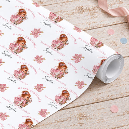 Roll of personalised granddaughter Christmas wrapping paper with a girl hugging a reindeer, pink snowflakes and gold stars