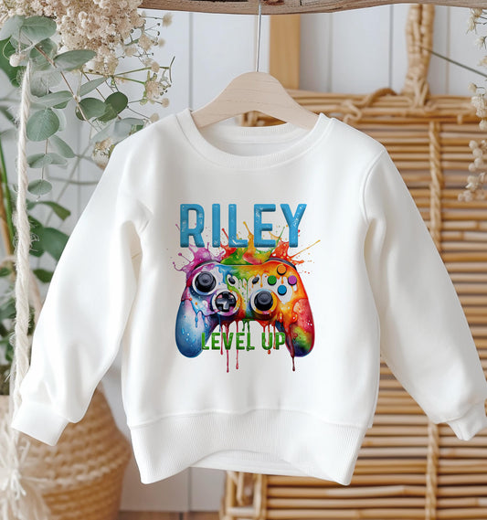 Personalised white cotton kids sweatshirt with colourful gaming controller print and custom name, size 6-12 months