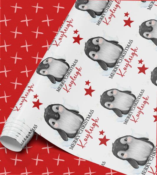 Repeating pattern of penguin illustrations and red stars on personalised Christmas wrapping paper