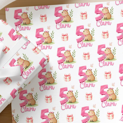 Repeating pattern of capybaras in pink tones on personalised birthday wrapping paper for girls