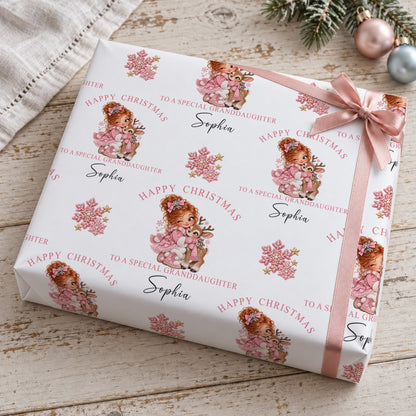 Gift wrapped in personalised girl and reindeer Christmas wrapping paper tied with a pink satin bow