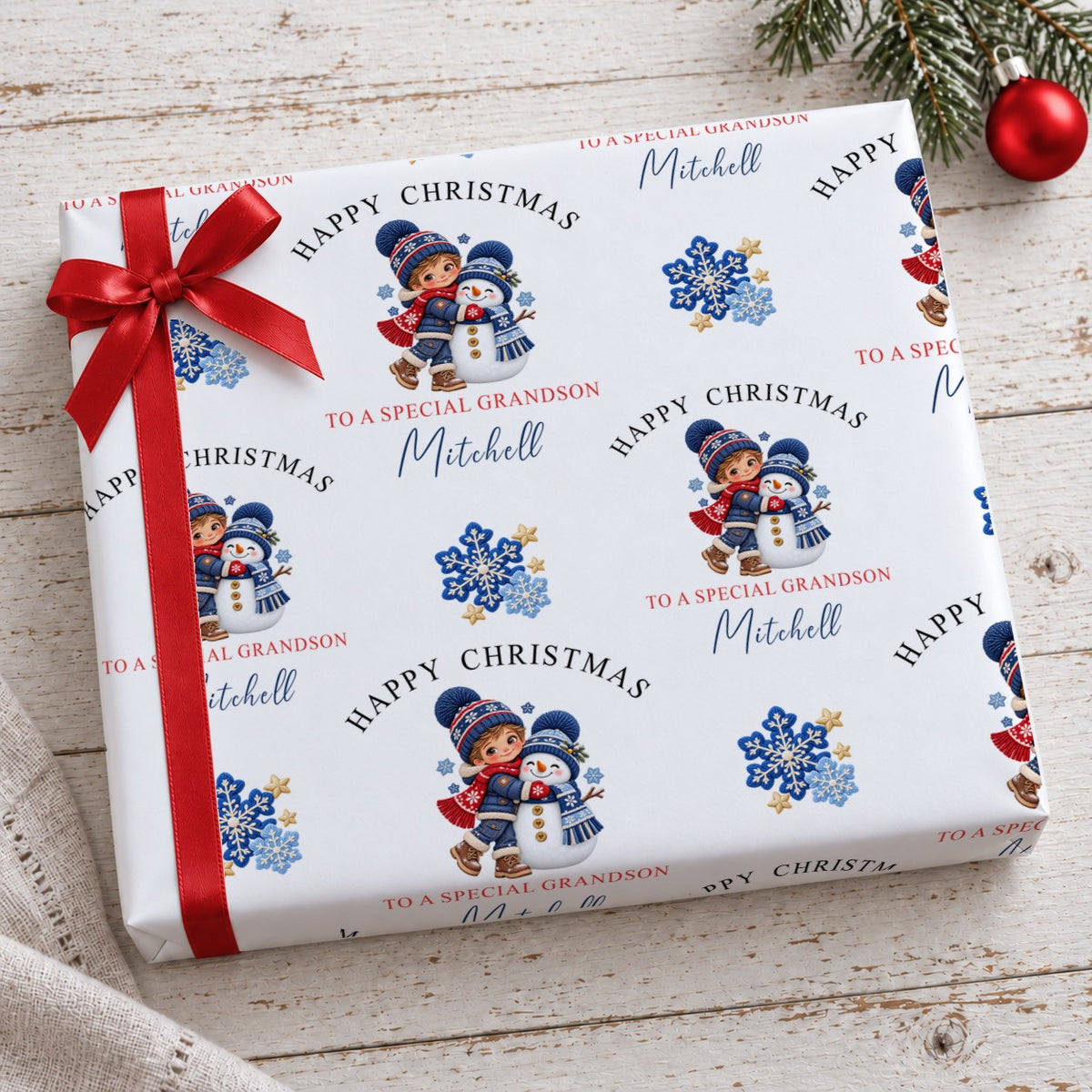 Gift wrapped in personalised boy and snowman Christmas wrapping paper tied with a red satin bow