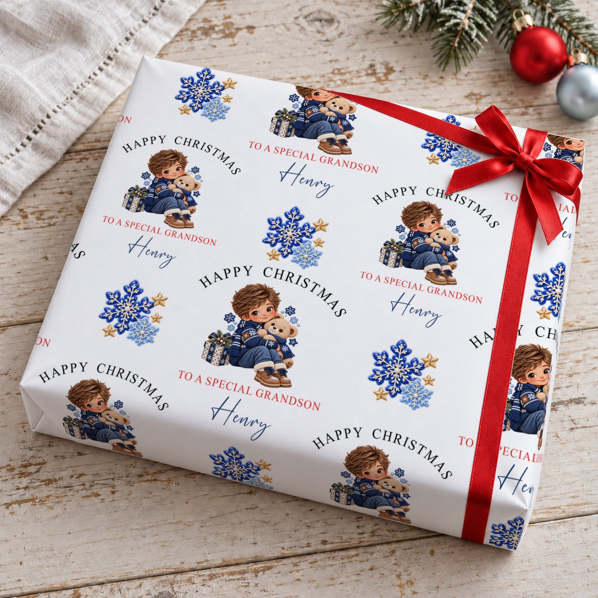 Gift wrapped in personalised boy and teddy bear Christmas wrapping paper tied with a red satin bow