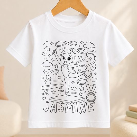 Line-art colour-in design of a gymnast leaping with a ribbon on a balance beam, with a medal alongside, printed on a white kids' t-shirt with a personalised name below