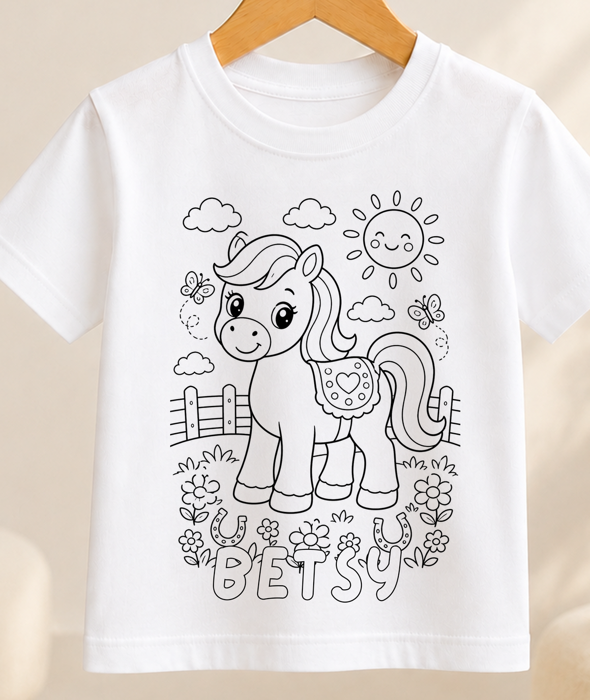 Colour-in kids t-shirt with a black-and-white line art horse and pony in a paddock scene, personalised with a name