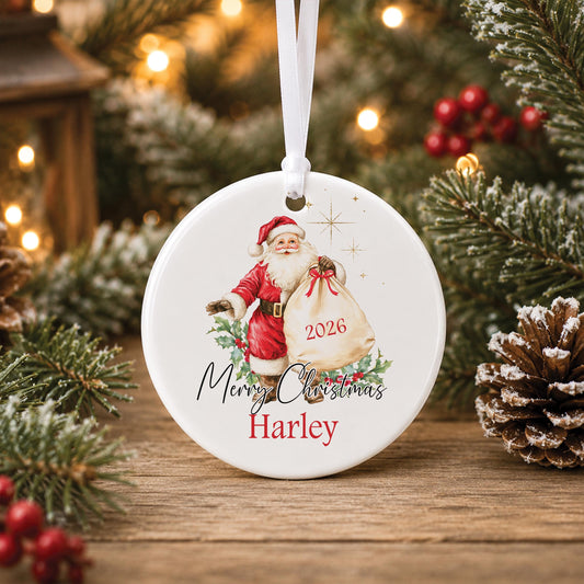Personalised round ceramic Christmas bauble featuring a vintage watercolour Father Christmas holding a gift sack, festive holly, Merry Christmas wording, a name and year