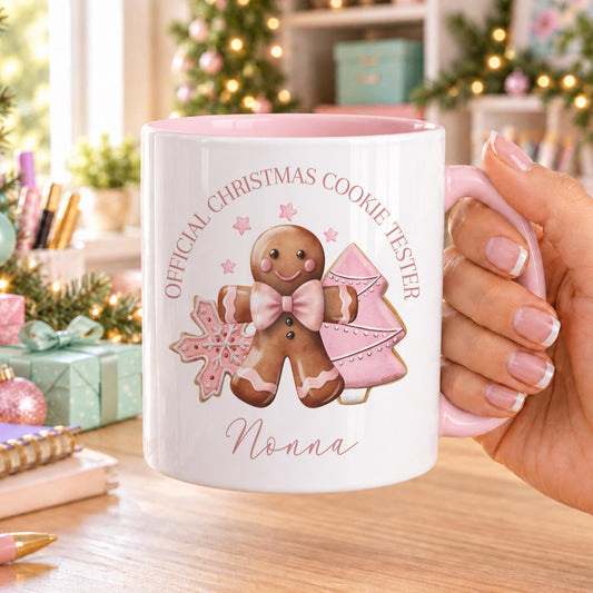 Personalised Christmas mug with pink handle and inside, printed with a gingerbread man in a pink bow and iced cookies under Official Christmas Cookie Tester, with a name below