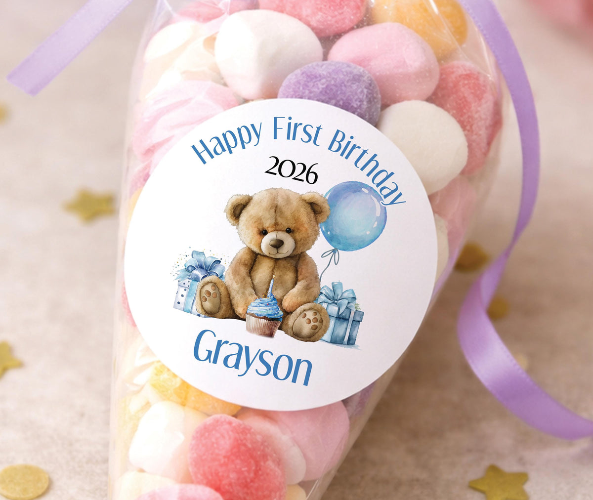 Glossy round stickers featuring a blue teddy bear first birthday design, personalised with the child's name and age.