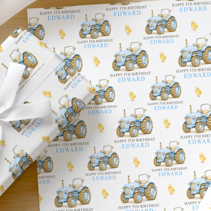 Personalised blue tractor wrapping paper printed with a custom name and age, shown as a full sheet