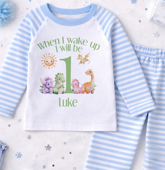 A white and blue striped onesie with a personalized text and illustrations on it, along with a pair of blue and white striped pajama pants.
