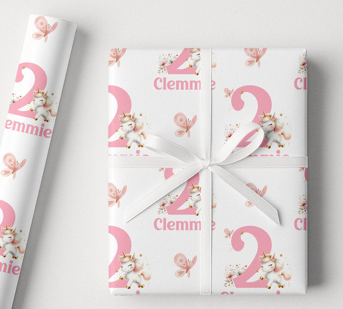 A gift wrapped in personalised pink and white unicorn wrapping paper, finished with a white ribbon
