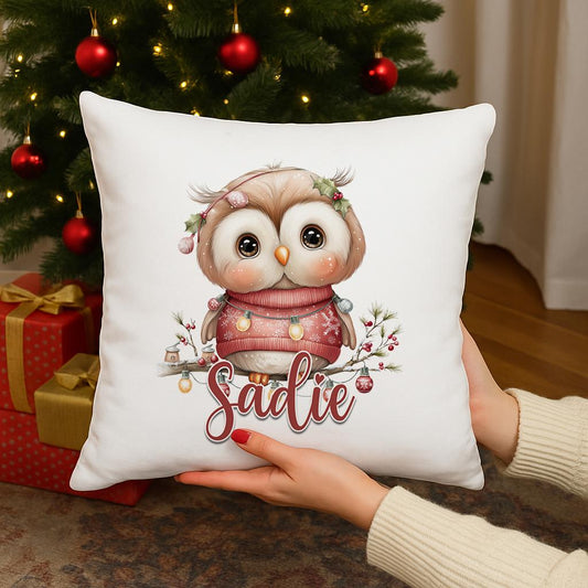 Square cushion personalised with a name, printed with an owl wearing a red winter jumper among fairy lights and holly