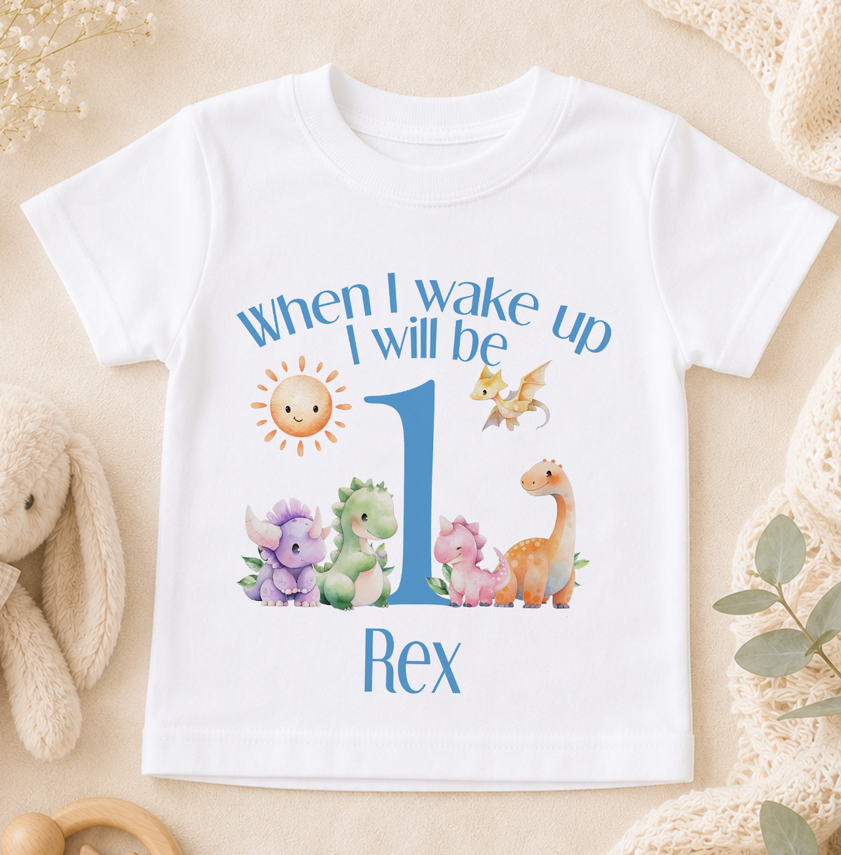 A white t-shirt with a personalized design featuring a cartoon dinosaur and the text "When I wake up I will be Rex" printed on it.