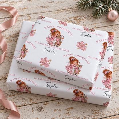 Stacked gifts wrapped in personalised girl and reindeer Christmas wrapping paper printed with a name