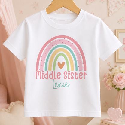 A white t-shirt with a colorful rainbow graphic and the text "Middle Sister Lexie" printed on it.