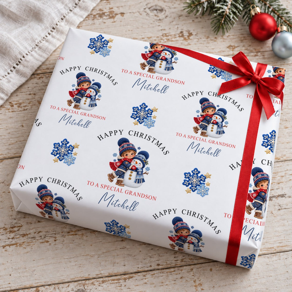 Present wrapped in personalised Happy Christmas To A Special Grandson snowman wrapping paper with a red bow