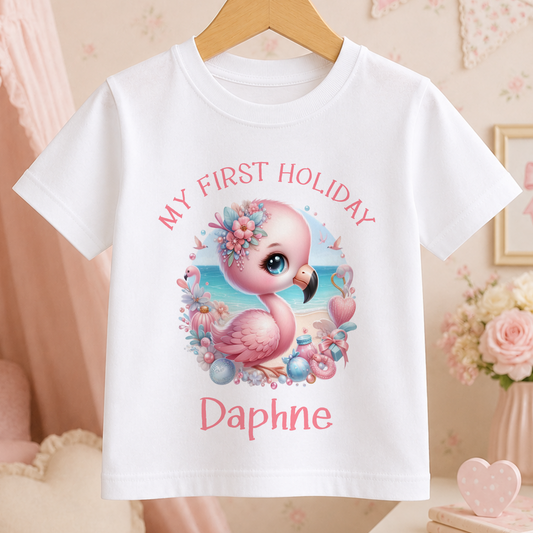 A white t-shirt with a pink flamingo graphic and the text "My first holiday Daphne" printed on it.