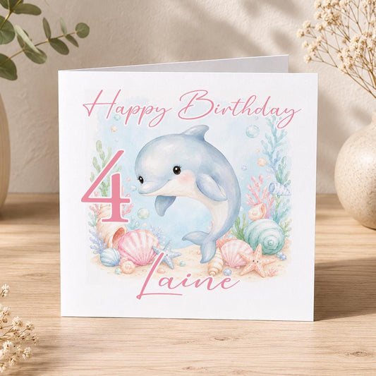 Square personalised birthday card featuring an ocean-themed dolphin design, personalised with the birthday child's name and age.