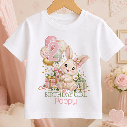 Personalised white t-shirt with a cream bunny in a pink gingham bow, balloons and daisies with an age number and Birthday Girl above a name