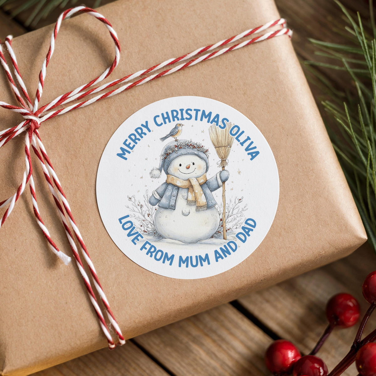 Brown gift box finished with a personalised glossy round snowman Christmas sticker reading 'Merry Christmas' with a custom name