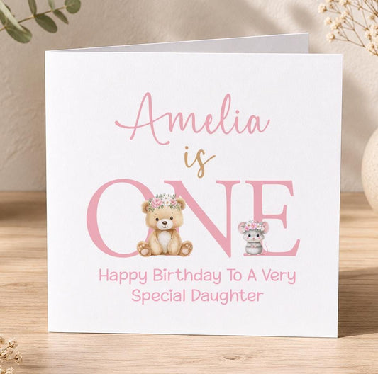 Personalised first birthday card, white 6x6 inch square card printed with a name in pink script above a large ONE with a teddy bear and mouse
