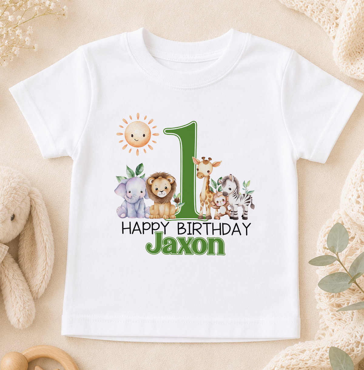 A white t-shirt with a graphic design featuring a sun, a lion, a giraffe, and a zebra, along with the text "Happy Birthday Jaxon".