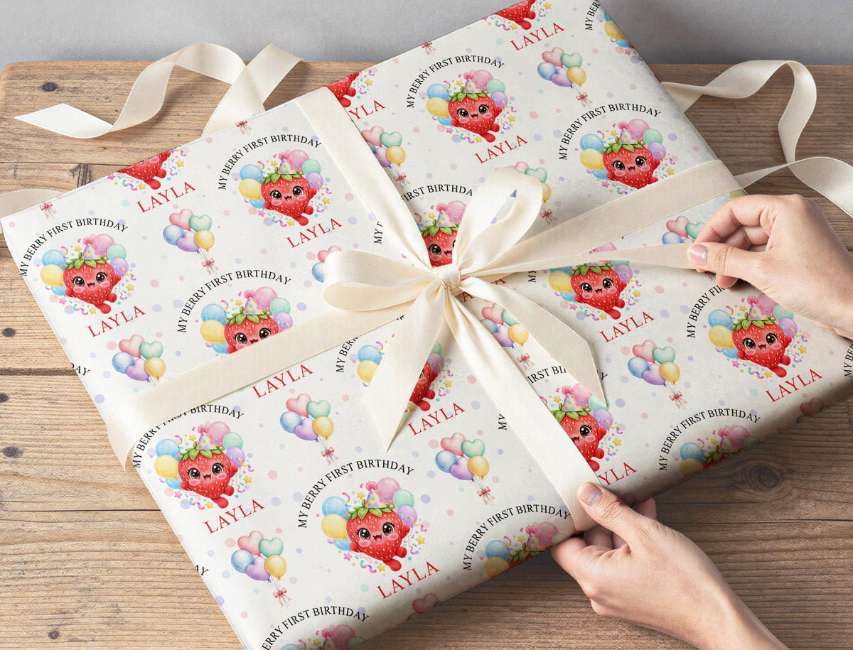 Gift wrapped in personalised strawberry first birthday wrapping paper tied with a cream ribbon