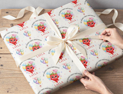 Gift wrapped in personalised strawberry first birthday wrapping paper tied with a cream ribbon