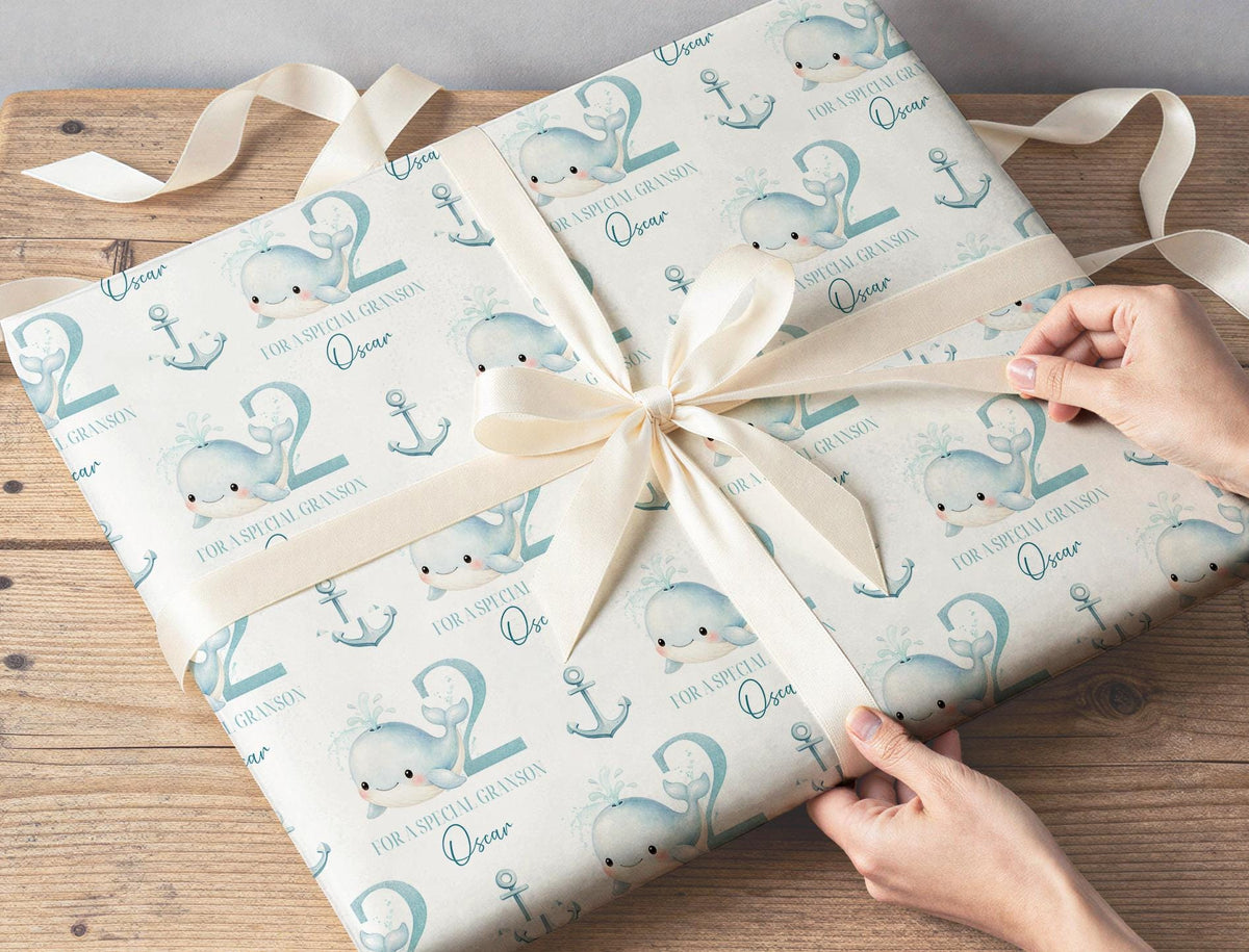 Roll of personalised whale gift wrap for boys standing upright