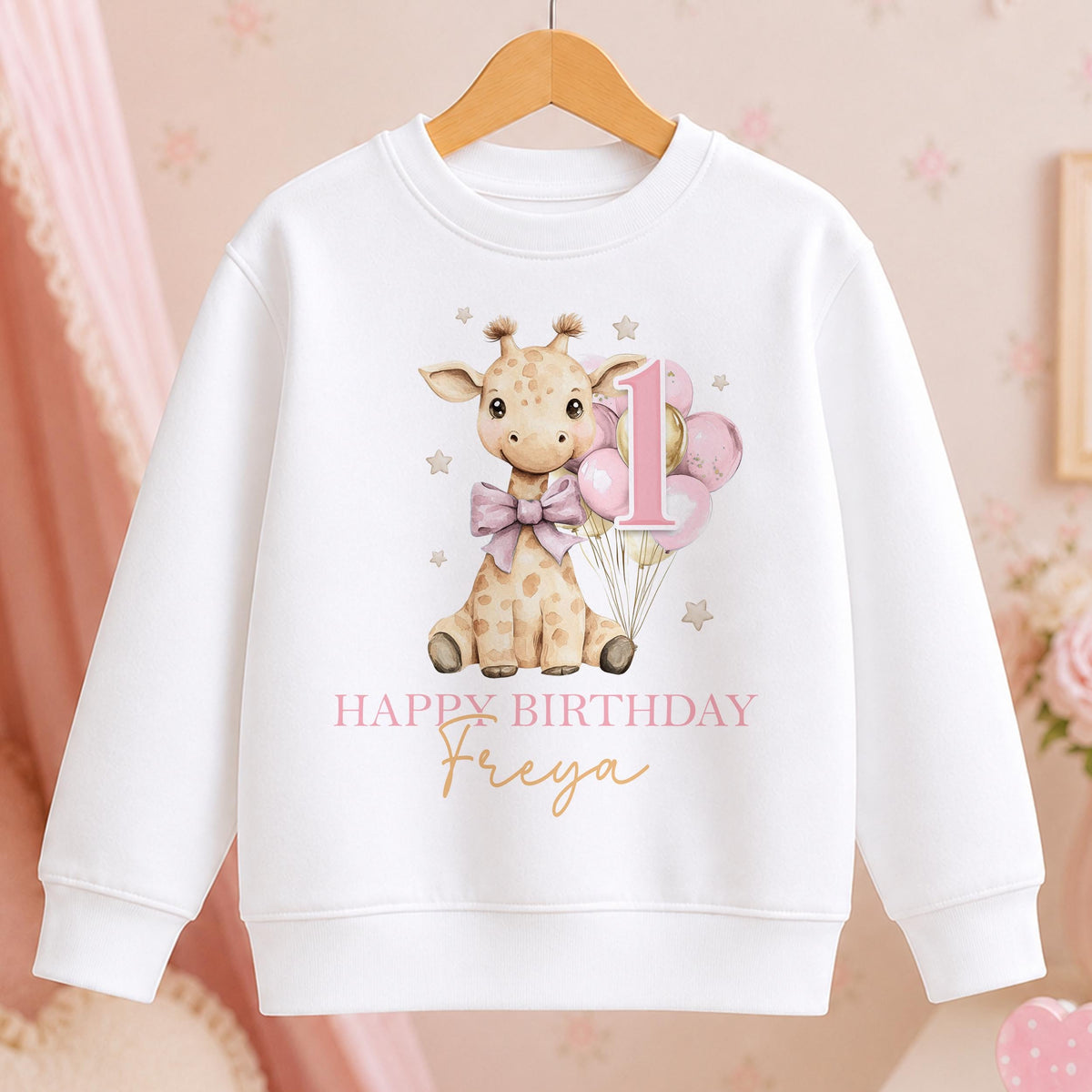 Personalised white birthday sweatshirt with a watercolour giraffe holding pink balloons with the number 1, “Happy Birthday” and a name