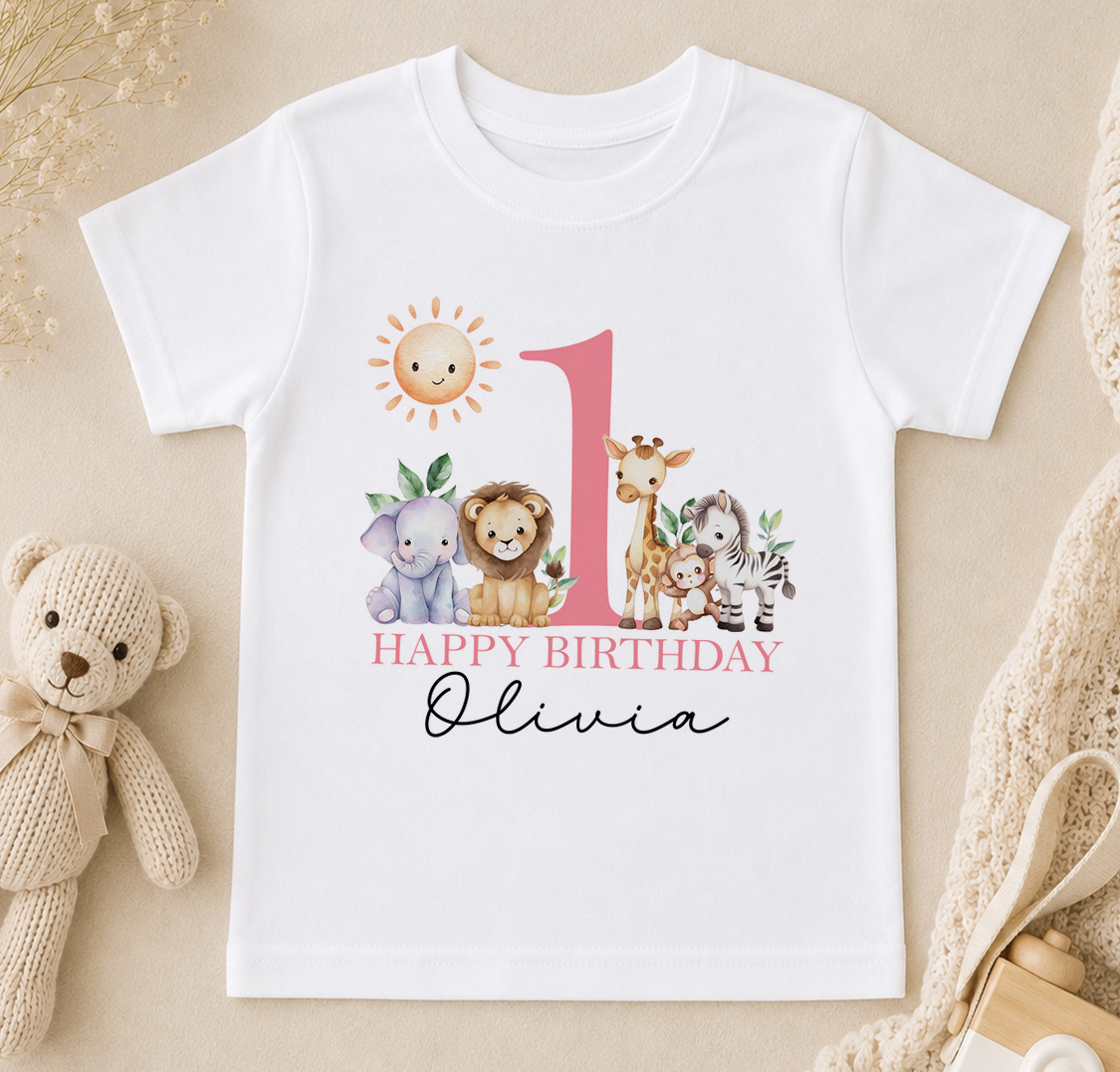 A white t-shirt with a printed design of various animals, including a sun, a giraffe, a lion, and a zebra, along with the text "Happy Birthday Olivia".