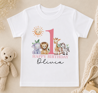 A white t-shirt with a printed design of various animals, including a sun, a giraffe, a lion, and a zebra, along with the text "Happy Birthday Olivia".