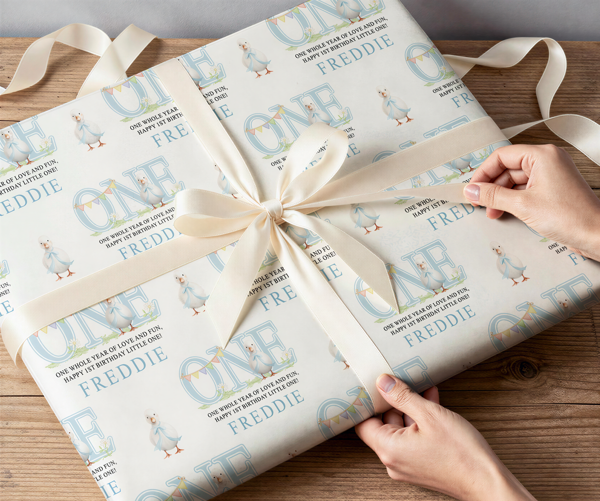 Close-up of the blue duck 1st birthday wrapping paper pattern with a personalised name