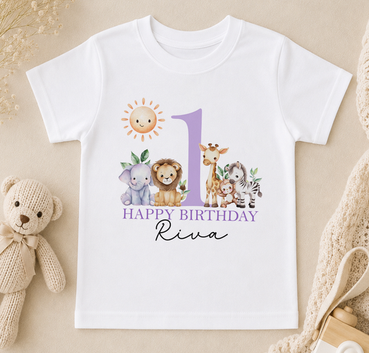 A white t-shirt with a graphic design featuring a sun, a giraffe, an elephant, and a lion, along with the text "Happy Birthday Riva".