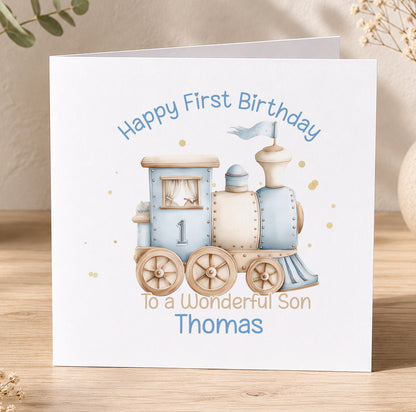 White 1st birthday card with a blue train illustration and the personalised message 'Happy First Birthday To a Wonderful Son Thomas'