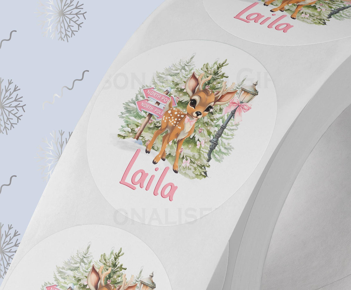 Personalised pink baby reindeer Christmas sticker on white gloss paper, custom name printed on a strip of 5cm round labels
