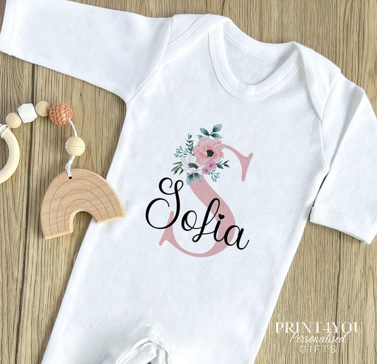 Personalised pink floral initial baby bib, printed with the child's custom name and initial.