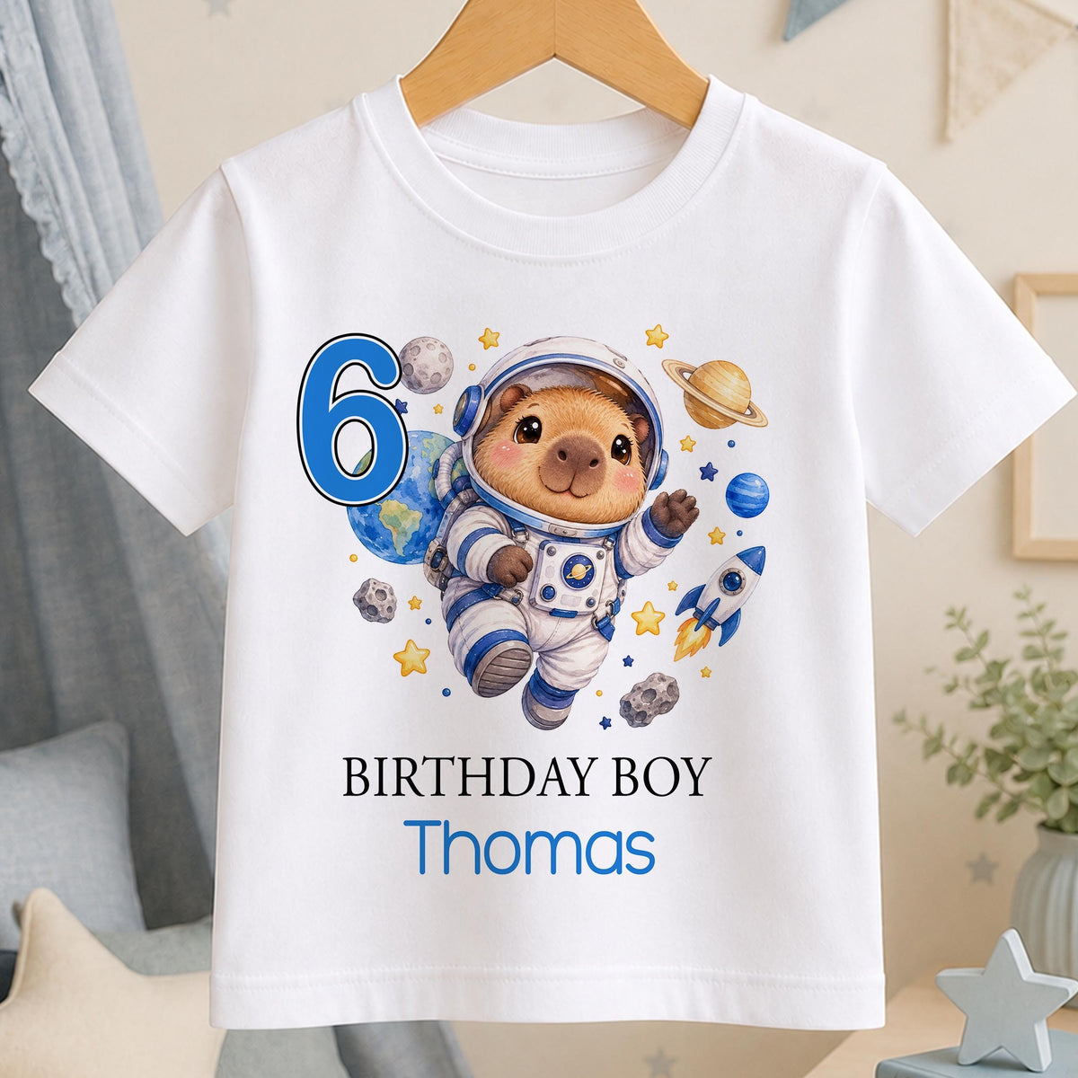 Personalised capybara astronaut birthday t-shirt – white tee with a capybara astronaut among planets, blue number 6, Birthday Boy and the name Thomas
