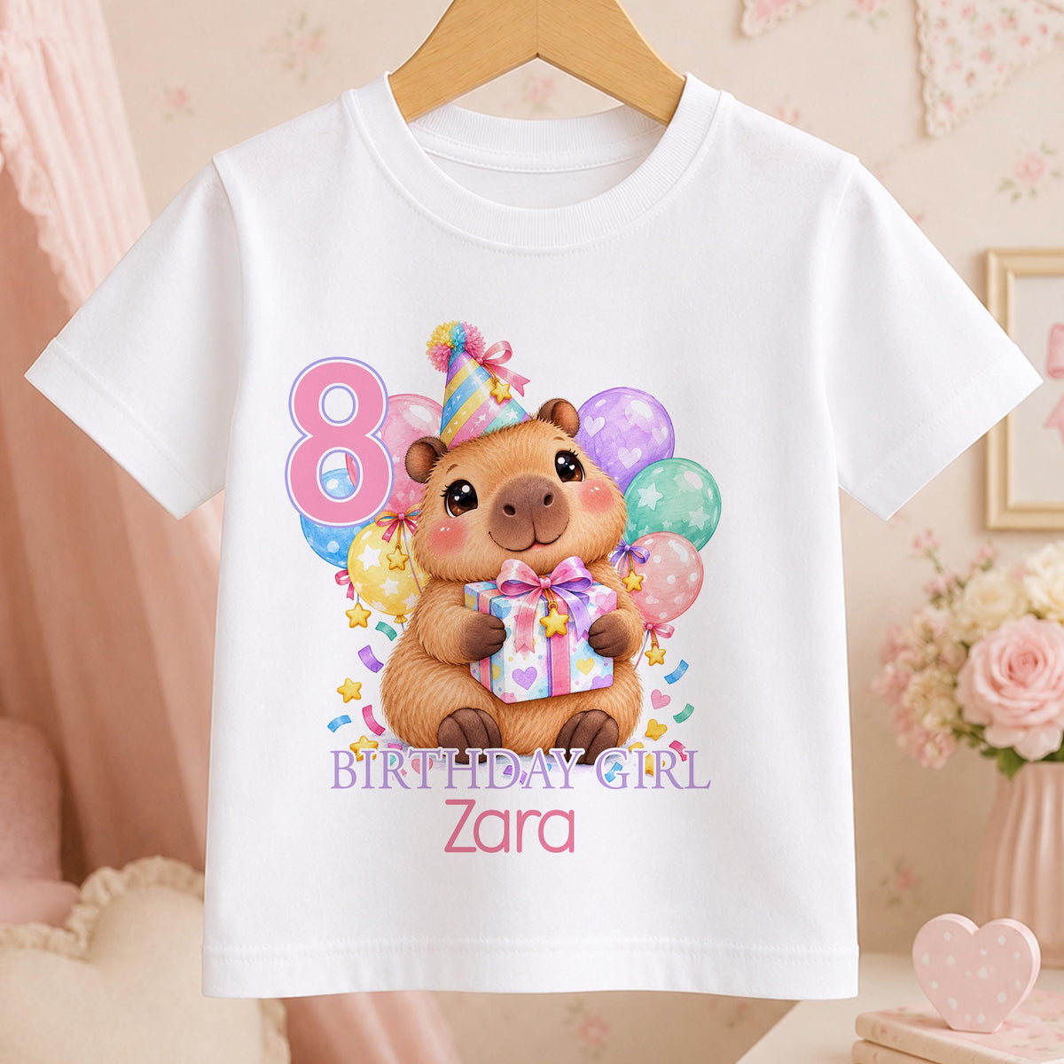Personalised capybara birthday t-shirt – white tee with a capybara in a party hat holding a present with balloons, pink number 8, Birthday Girl and the name Zara