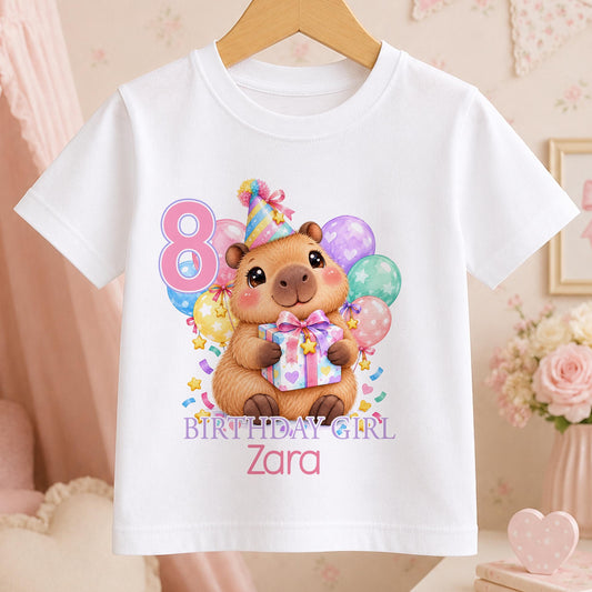 Personalised capybara birthday t-shirt – white tee with a capybara in a party hat holding a present with balloons, pink number 8, Birthday Girl and the name Zara