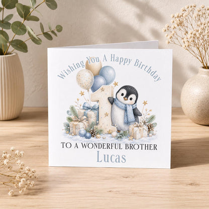 Personalised penguin 1st birthday card – penguin in a blue scarf with a number 1, To a Wonderful Brother Lucas